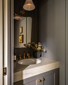 a bathroom sink sitting under a mirror next to a wall mounted faucet with lights on it