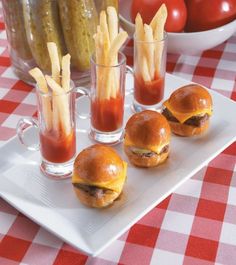 mini burgers and french fries on a white plate with red checkered tablecloth