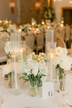 there are many vases with flowers in them on the table at this wedding reception