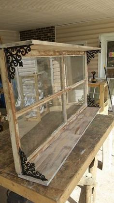 an old window sitting on top of a wooden table