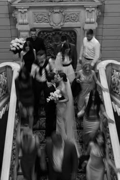 a group of people standing on top of an escalator next to each other