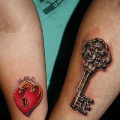 two people with matching tattoos on their arms holding keys and heart shaped key to each other