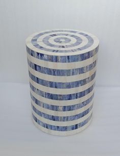 a blue and white striped box with a spiral design on the top, sitting on a table