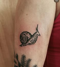 a small snail tattoo on the arm