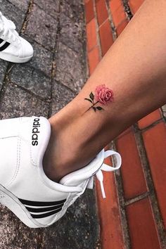 a woman's foot with a rose tattoo on it