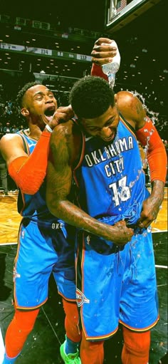 two basketball players hugging each other on the court