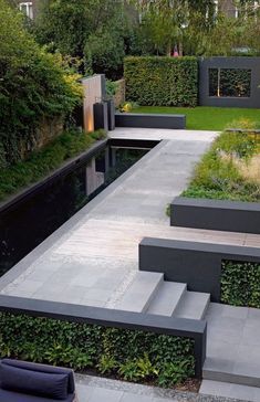 an outdoor garden with steps leading up to the water and plants growing on the walls