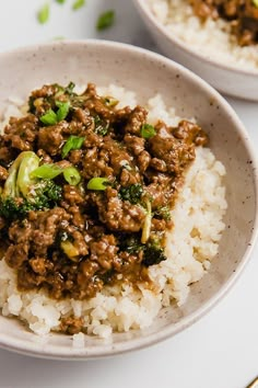 two bowls filled with rice, meat and broccoli on top of each other