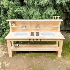 an outdoor sink made out of wood with two bowls on the front and one bowl on the back