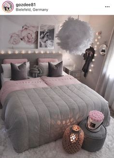 a bedroom decorated in grey and pink with lights