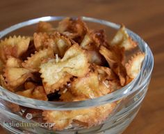 a glass bowl filled with fried food on top of a wooden table