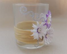 a close up of a glass with flowers on the rim and some beads in the middle