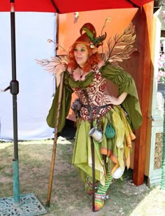 a woman dressed in costume standing under an umbrella