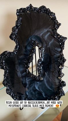 a black sculpture sitting on top of a glass table