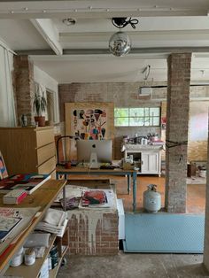 a room filled with lots of clutter next to a brick wall covered in pictures