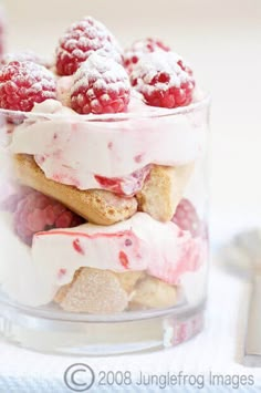 there is a small glass bowl filled with raspberry shortcakes and whipped cream