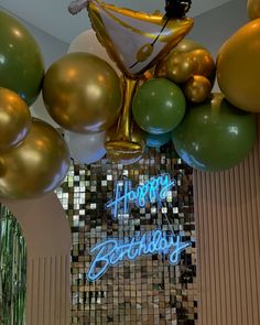 balloons and streamers are hanging from the ceiling in front of a happy birthday sign