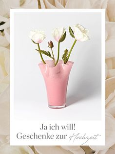 a pink vase filled with white flowers on top of a table