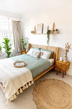 a bedroom with a bed, rugs and potted plants on the windowsill