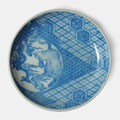 a blue and white plate with a dragon on it's side, in the shape of hexagonal tiles