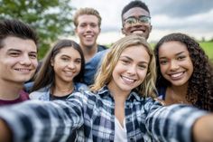 a group of young people taking a selfie with their arms around each other and smiling