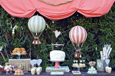 a table topped with cakes and hot air balloons