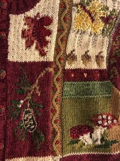 a close up of a knitted sweater with flowers and animals on it's side