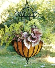 a hanging planter filled with lots of flowers and greenery next to a forest