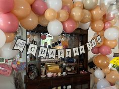 balloons and streamers are hanging from the ceiling above a table with drinks on it