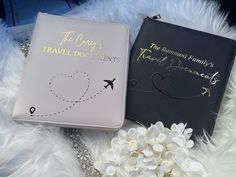 two passport cases sitting on top of a white furnishce covered floor next to a bouquet of flowers