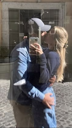 a man and woman taking a selfie in front of a building with a camera