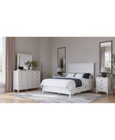 a white bed sitting in a bedroom next to a dresser and mirror on top of a wooden floor