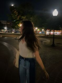 a woman walking down the street at night