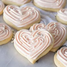 heart shaped cookies with frosting sitting on a table