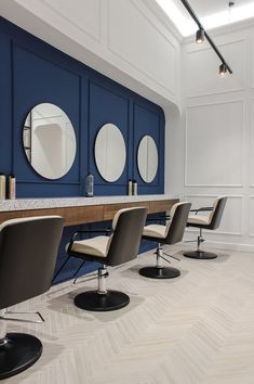 an empty room with chairs and mirrors on the wall, in front of a counter