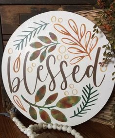 a white plate with the words, blessed painted on it next to a beaded bracelet