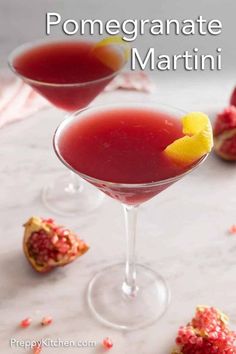 pomegranate martini in coupe glasses garnished with orange peel and pomegranate