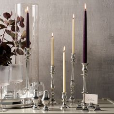 a table topped with candles next to a vase filled with flowers