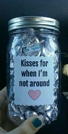 someone holding up a jar with some kind of candy in it that says kisses for when i'm not around