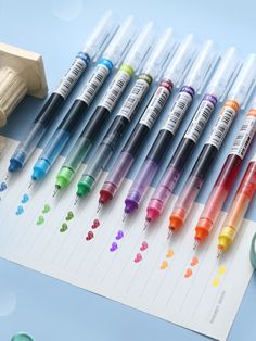 many different colored markers are lined up next to each other on a sheet of paper