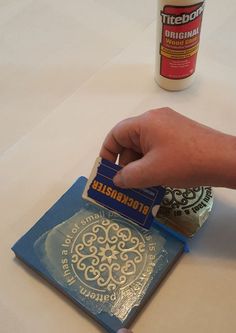 a person is stamping something on a piece of paper with a blue and gold color