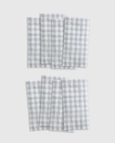 four napkins with gingham checks on them, one is folded and the other has