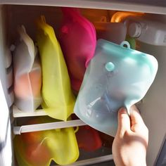 a person is opening the refrigerator door to see what's in its plastic container