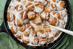 a pan filled with cinnamon rolls covered in icing