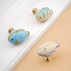 three decorative door knobs with fish designs on them