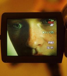 a close up of a person's face on a video camera with the screen showing