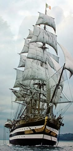 a large white sail boat floating on top of the ocean