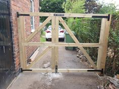 a car is parked in front of a house through an open gate that has been made to look like a triangle