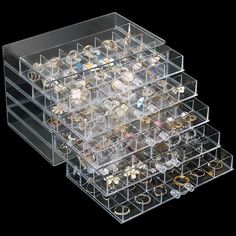 three clear acrylic boxes with various jewelry inside on a black backgroud