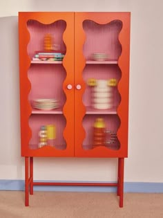 a red cabinet with glass doors and shelves